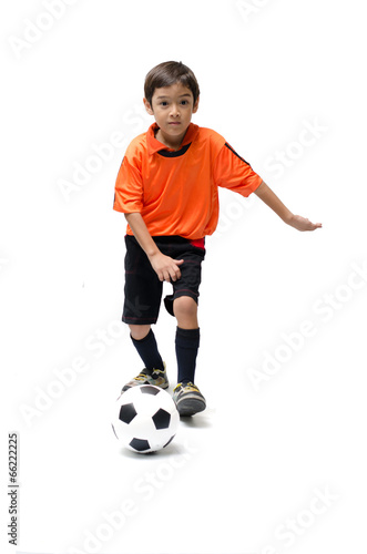 Little boy kicking football on white background