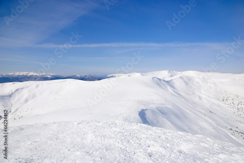 WInter snowy mountains landscape with blue sky