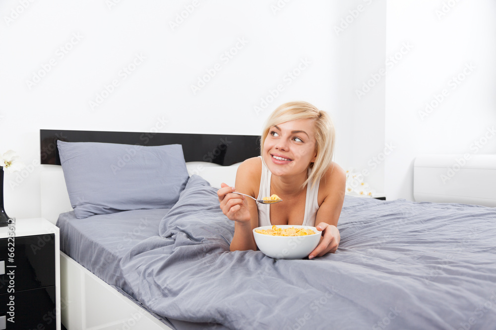 Breakfast in bed, young woman lying on bed Breakfast in bed, young woman lying on bed