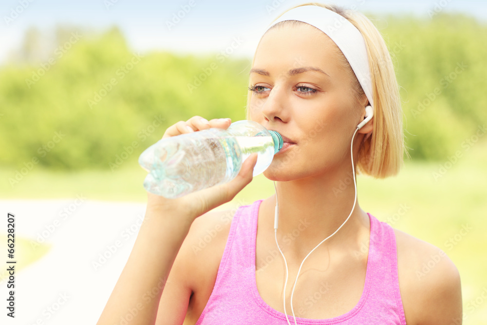 Runner drinking water in the park Runner drinking water in the park