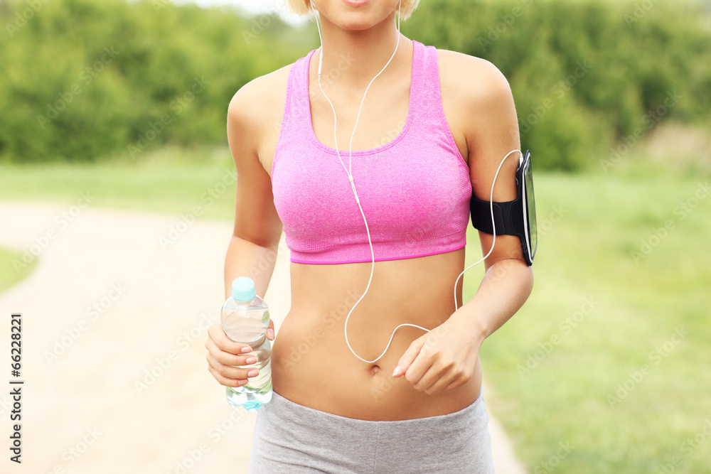 Midsection of a woman jogging in the park Midsection of a woman jogging in the park