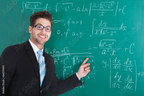 Confident Professor Standing Against Blackboard