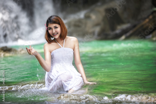 Fototapeta Naklejka Na Ścianę i Meble -  Young asian woman near waterfall