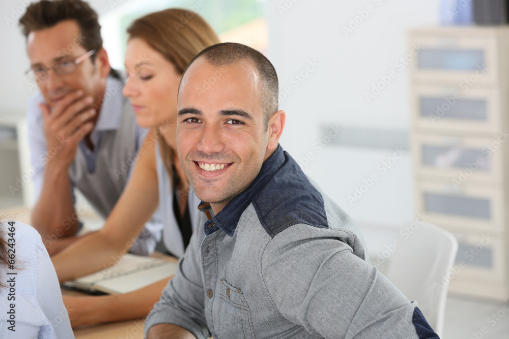 Smiling young businessman attending business training Smiling young businessman attending business training