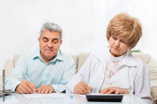 senior couple sign up document sitting sofa