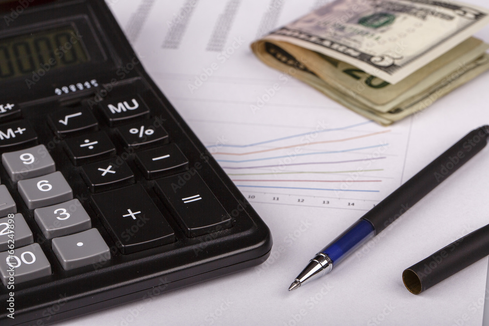 Business Charts with calculator, money and pen Business Charts with calculator, money and pen