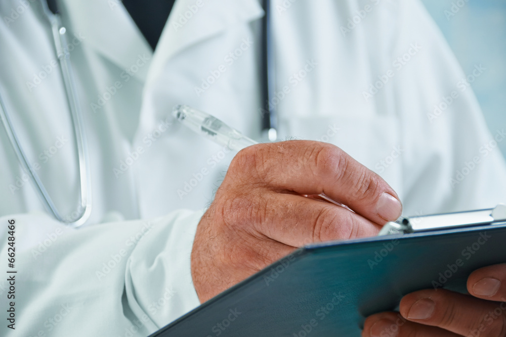 Older doctor writes medical records Older doctor writes medical records