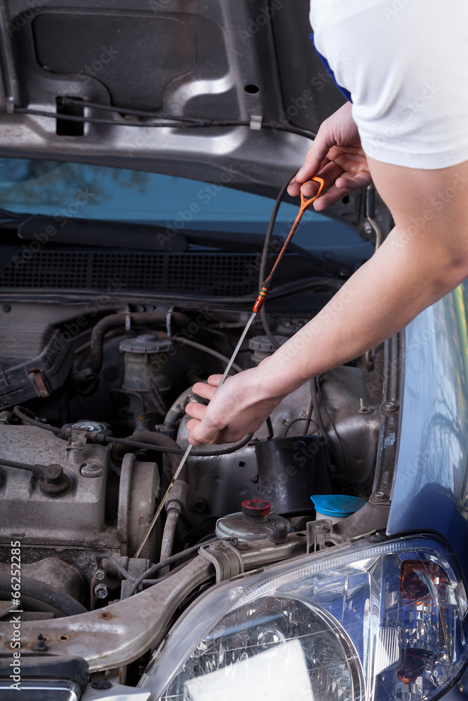 Mechanic checks the engine oil quantity Mechanic checks the engine oil quantity