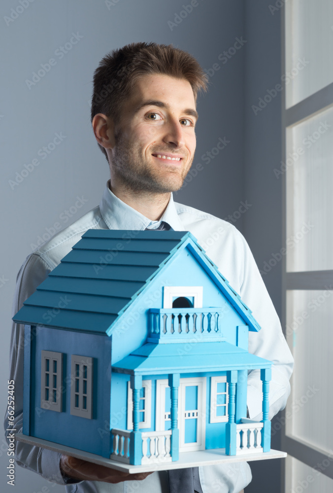 Real estate agent with model house Real estate agent with model house