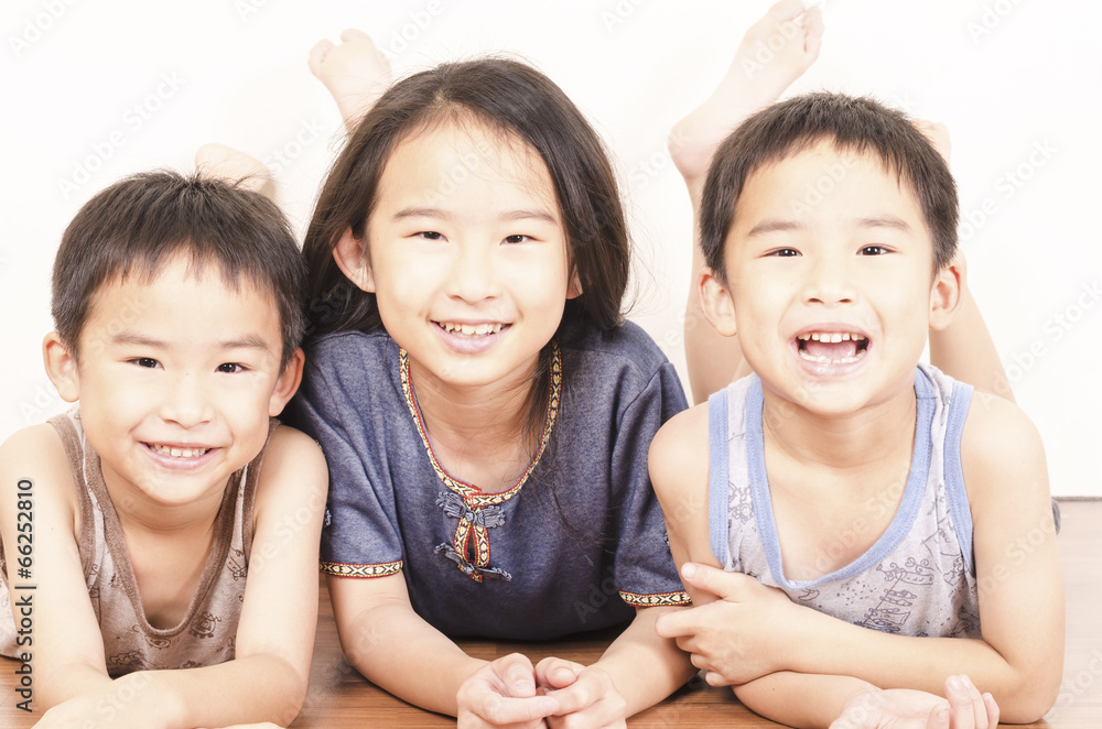 Three happy children lying on floor Three happy children lying on floor