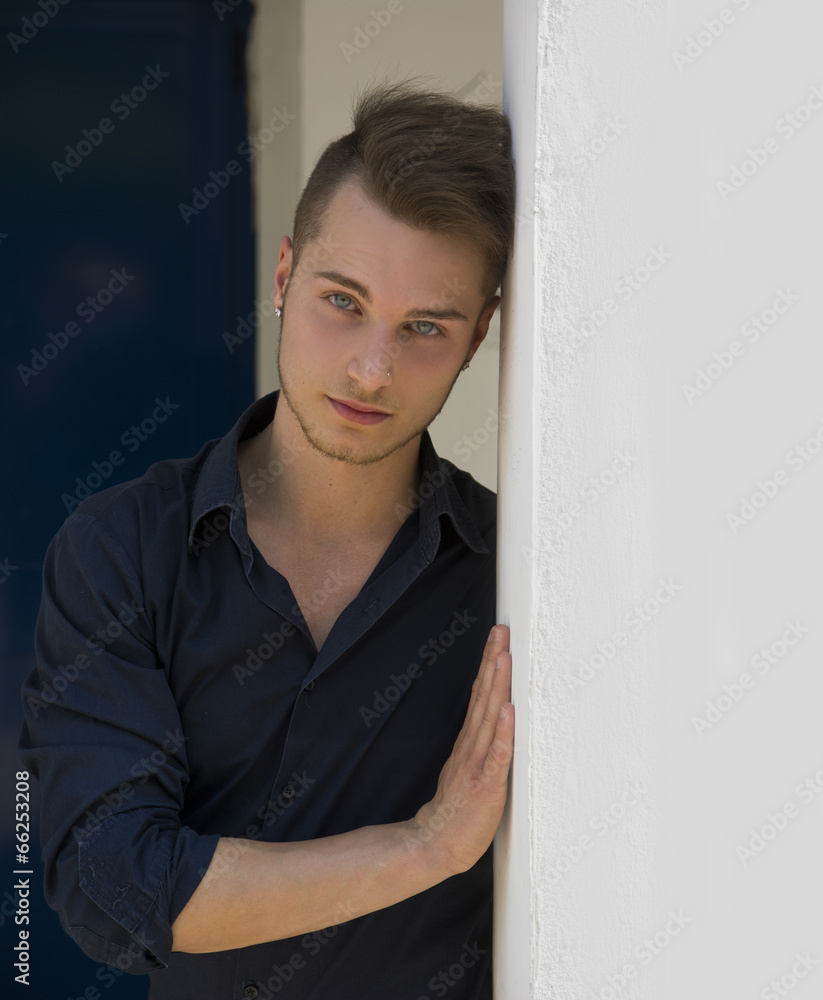 Attractive young blond man leaning against wall Attractive young blond man leaning against wall