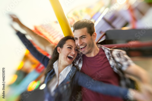 Laughing couple enjoy in riding ferris wheel