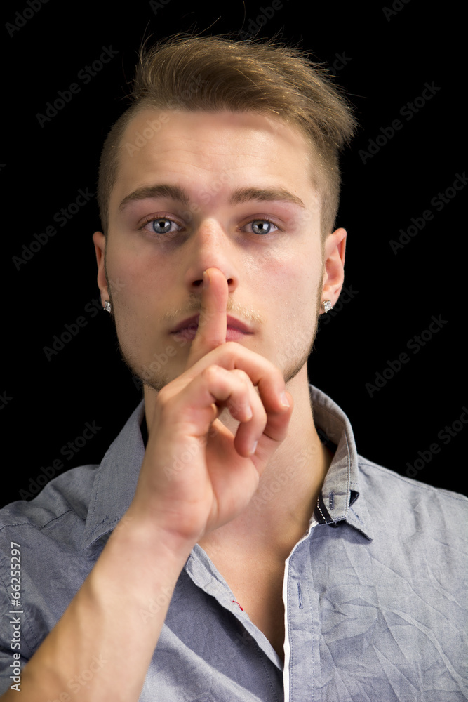 Attractive young man gesturing Hush or Silence Attractive young man gesturing Hush or Silence