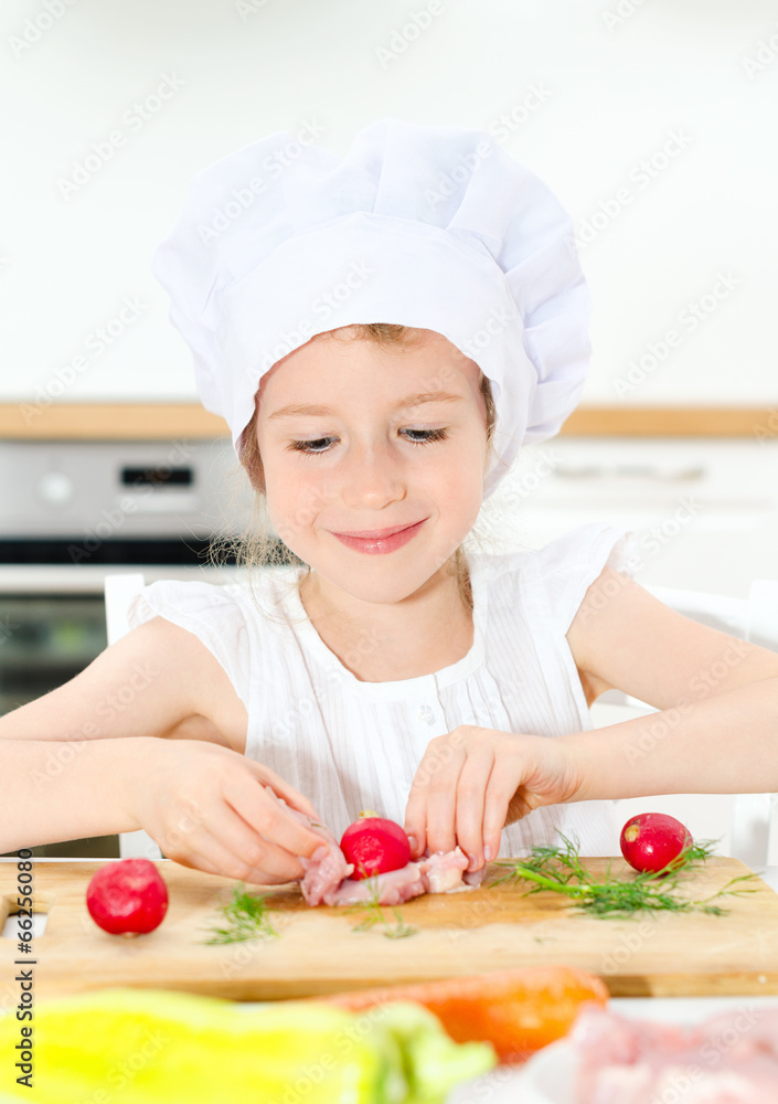 Little girl in chef hat cooking in kitchen. Little girl in chef hat cooking in kitchen.