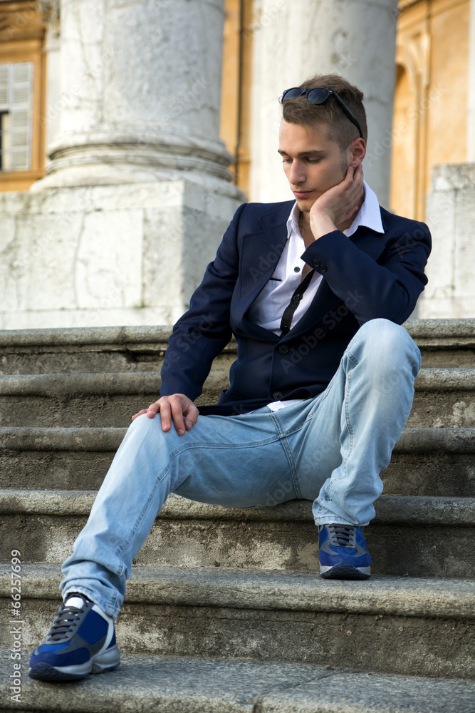 Handsome blond young man with marble columns behind him Handsome blond young man with marble columns behind him