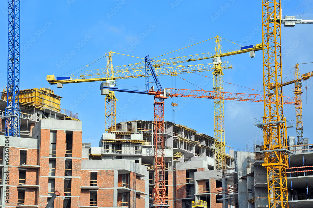 Crane and building construction site against blue sky Crane and building construction site against blue sky