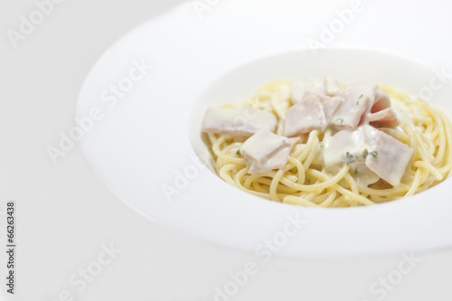 spaghetti with cream sauce on a white background