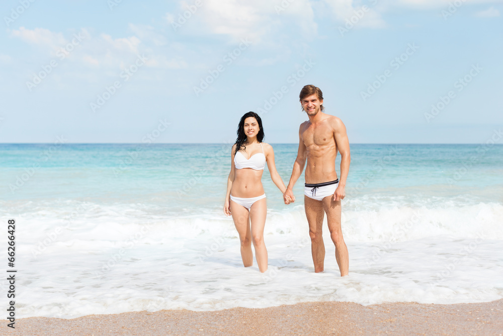 Couple on beach standing in water wave foam Couple on beach standing in water wave foam