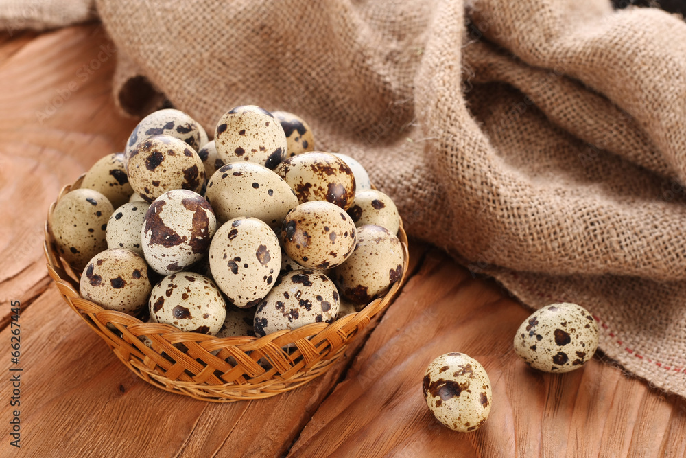 quail eggs in a wicker basket on the background of wooden planks quail eggs in a wicker basket on the background of wooden planks