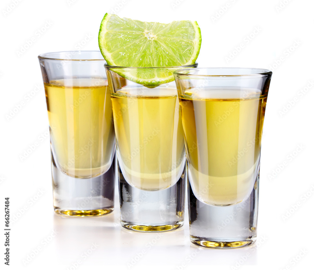 Three gold tequila shots with lime isolated on white Three gold tequila shots with lime isolated on white