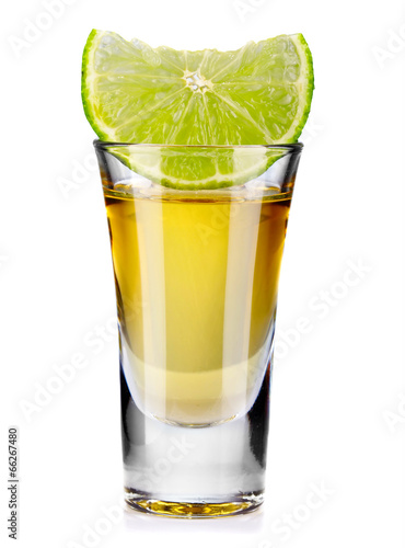 Gold tequila shot with lime isolated on white photo