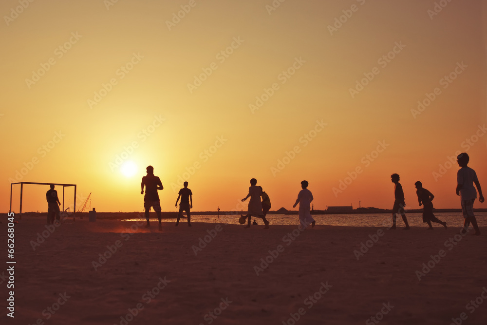 Football at  beach in Dubai during sunset.