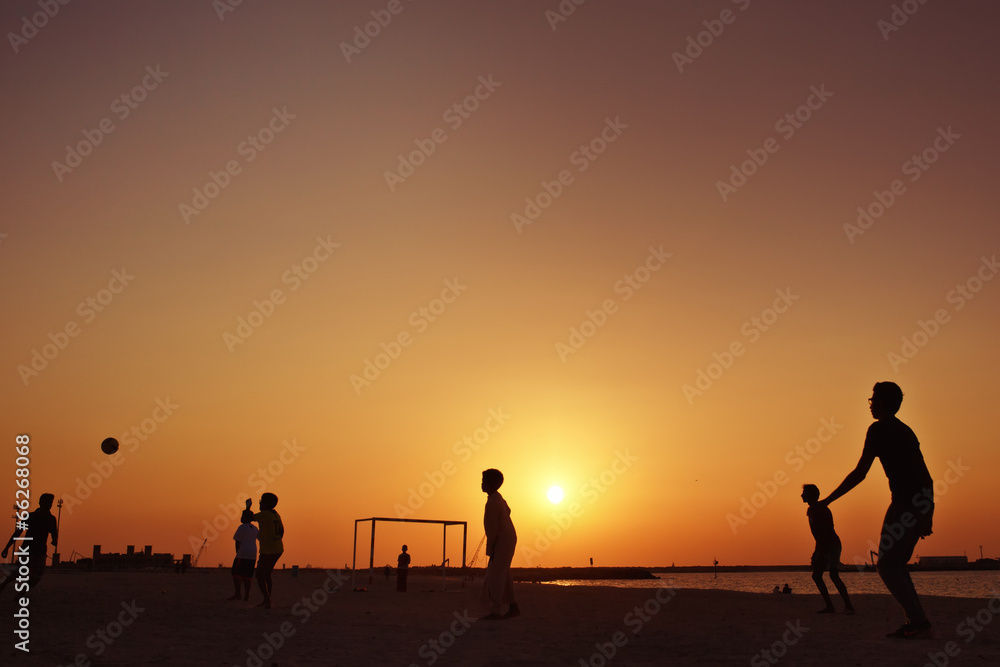 Football at  beach in Dubai during sunset.