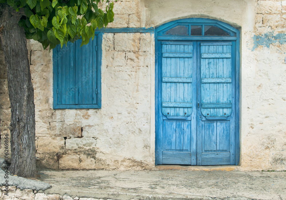 blue front door with window and tree in Cyprus