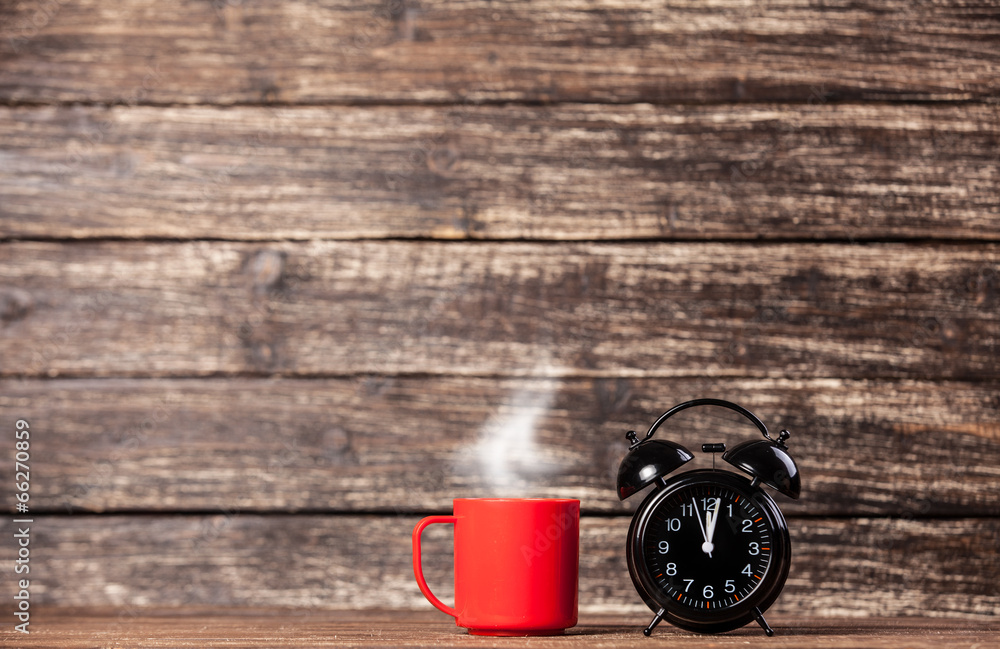 Tea or coffee cup and alarm clock Tea or coffee cup and alarm clock