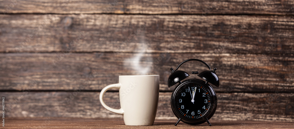 Tea or coffee cup and alarm clock Tea or coffee cup and alarm clock