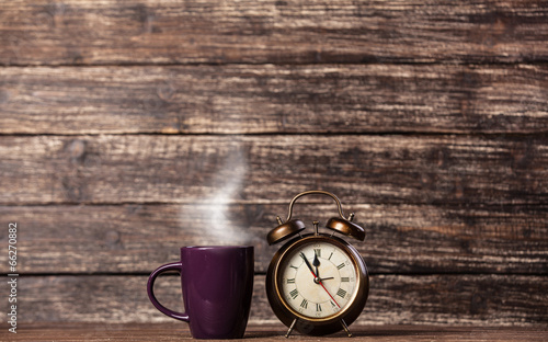 Tea or coffee cup and alarm clock