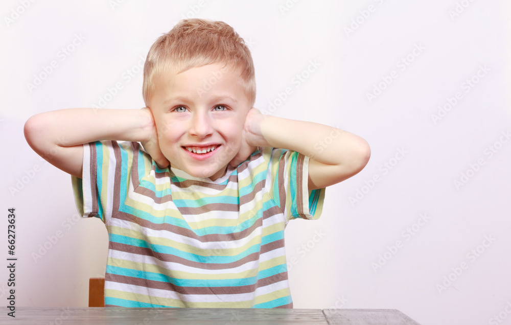 Portrait of blond boy child kid covering ears at the table Portrait of blond boy child kid covering ears at the table