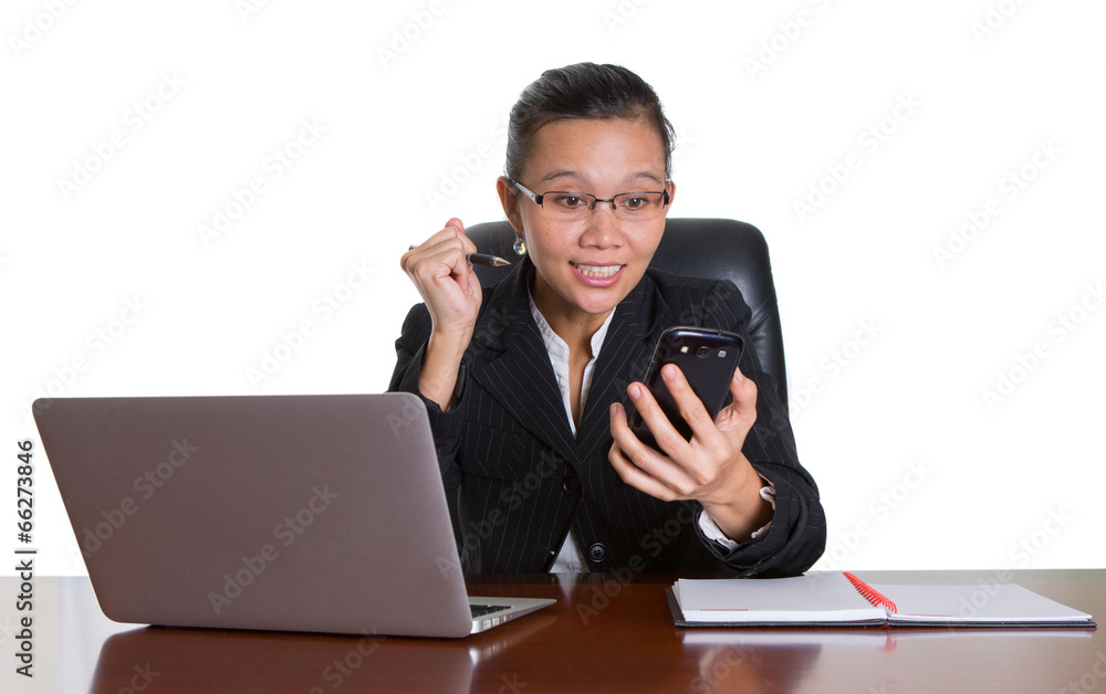 Asian businesswoman at her desk talking to a smart phone Asian businesswoman at her desk talking to a smart phone