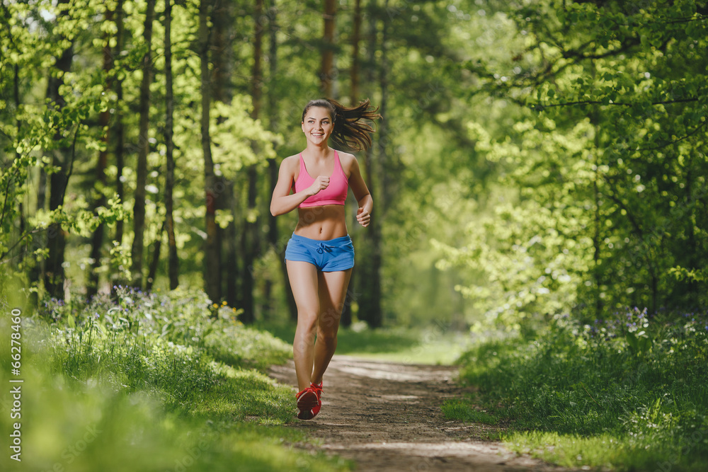 fitness girl running on forest trail and smiling fitness girl running on forest trail and smiling
