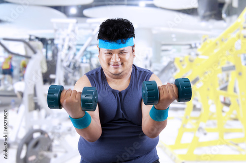 Fat man exercise in fitness center 2