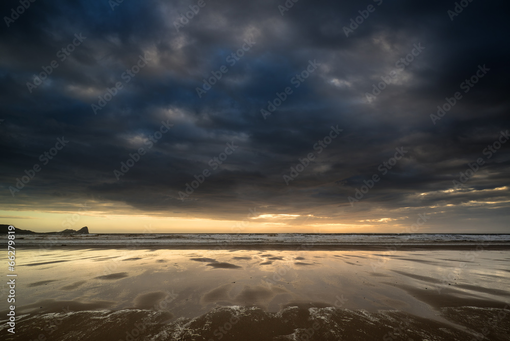 Dramatic stormy sky landscape reflected in low tide water on Rho