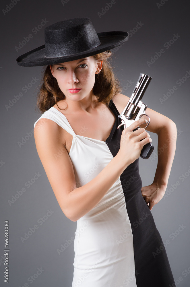 Woman with gun against dark background Woman with gun against dark background