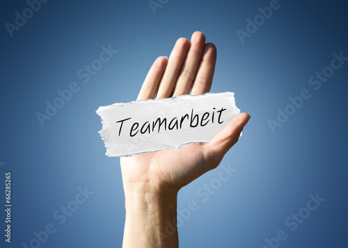 Man holding a scrap of paper with - Teamarbeit photo