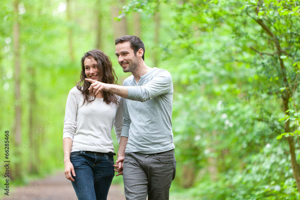 Fototapeta premium Young couple having a walk in a forest