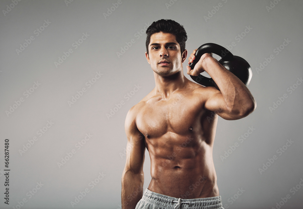 Fototapeta premium Muscular man performing crossfit workout with kettlebell