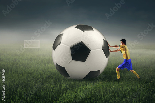 Soccer player with a big ball © Creativa Images
