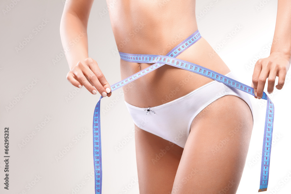 Slim Woman Body in Panties with Measure on white background