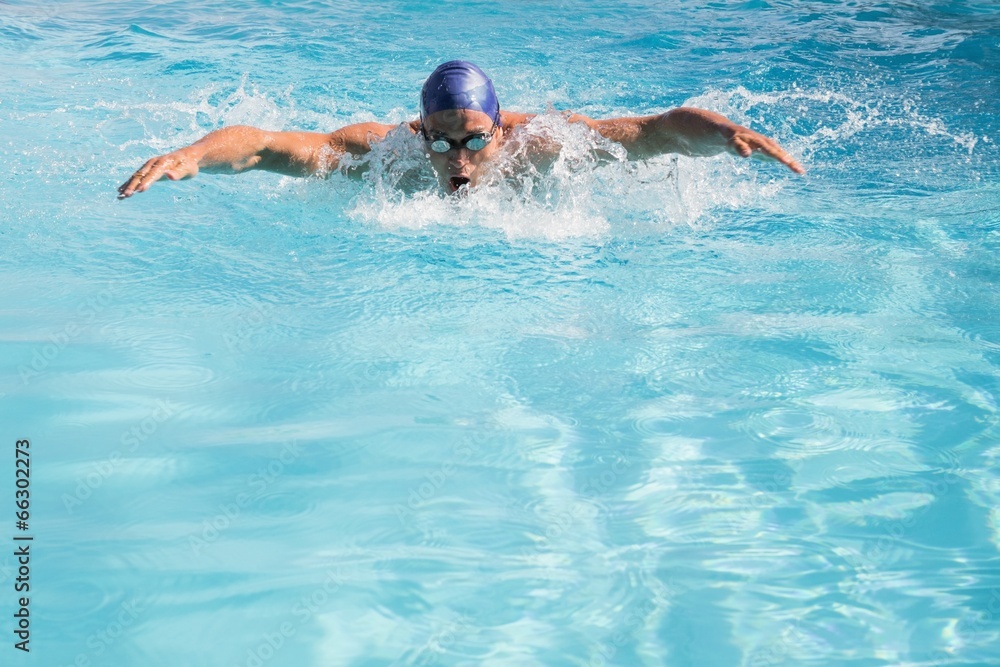 Fit swimmer doing the butterfly stroke in the swimming pool
