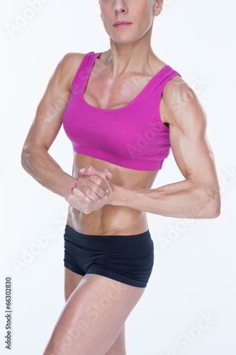 Female bodybuilder flexing in sports bra and shorts