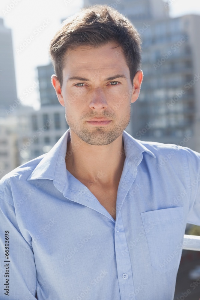 Handsome man frowning at camera on his balcony Handsome man frowning at camera on his balcony