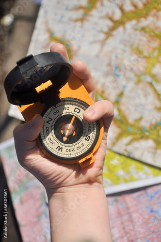 compass in his hand on the topographic maps. photo