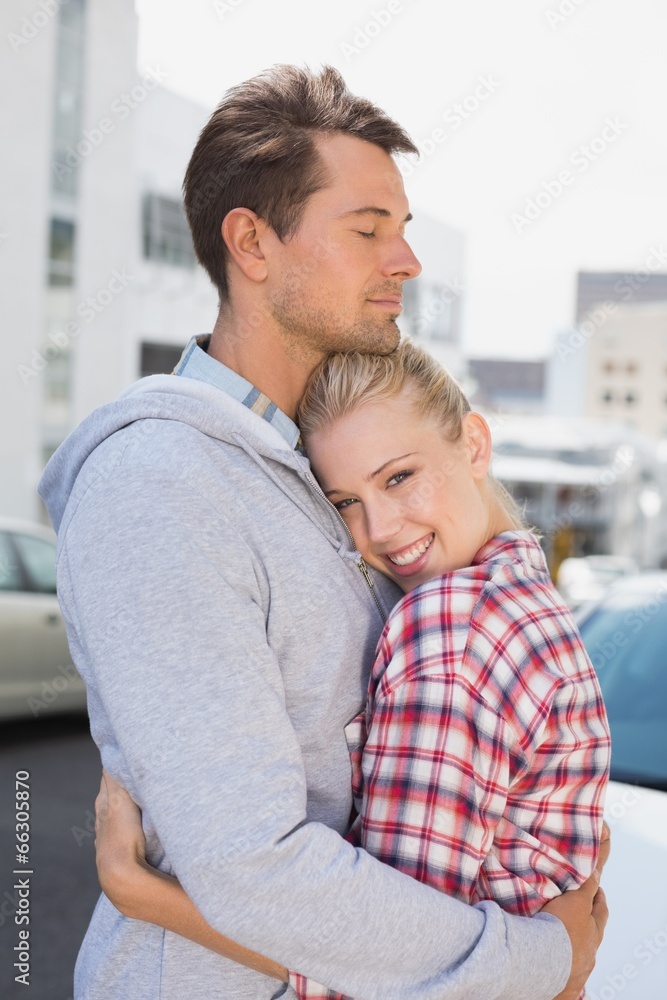 Hip young couple hugging woman smiling at camera Hip young couple hugging woman smiling at camera