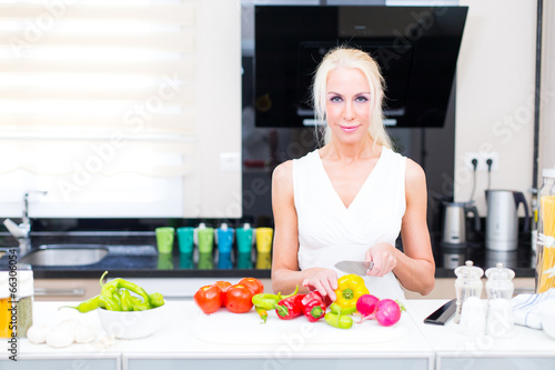 Happy woman cooks in the kitchen