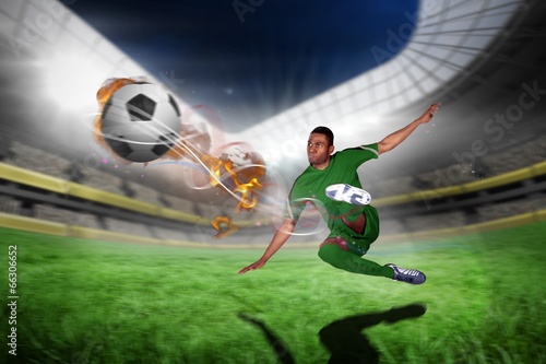 Composite image of football player in green kicking © WavebreakmediaMicro