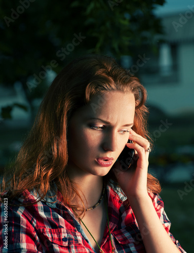 Redhead girl calling by mobile phone